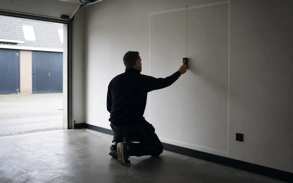 Thuisaccu gemonteerd aan garage-muur met ventilatieruimte